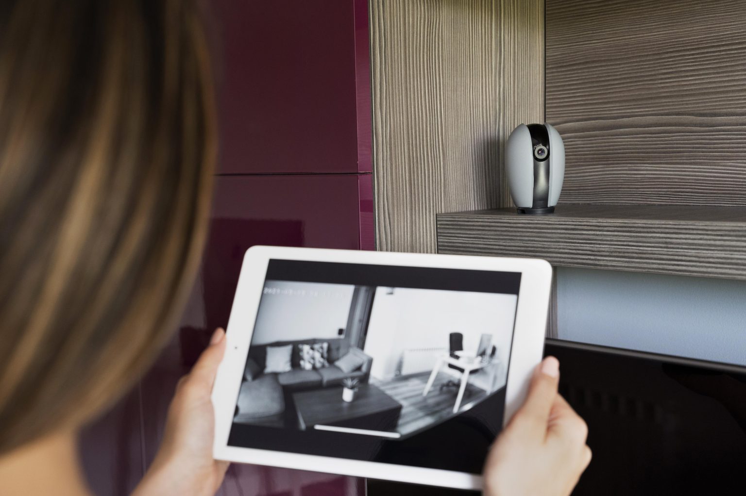 Homeowner viewing security camera footage remotely on a tablet