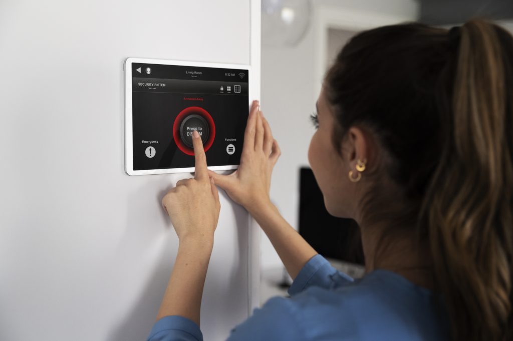 Homeowner arming a wall-mounted smart security panel